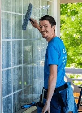 a man washing a residential window in colorado springs