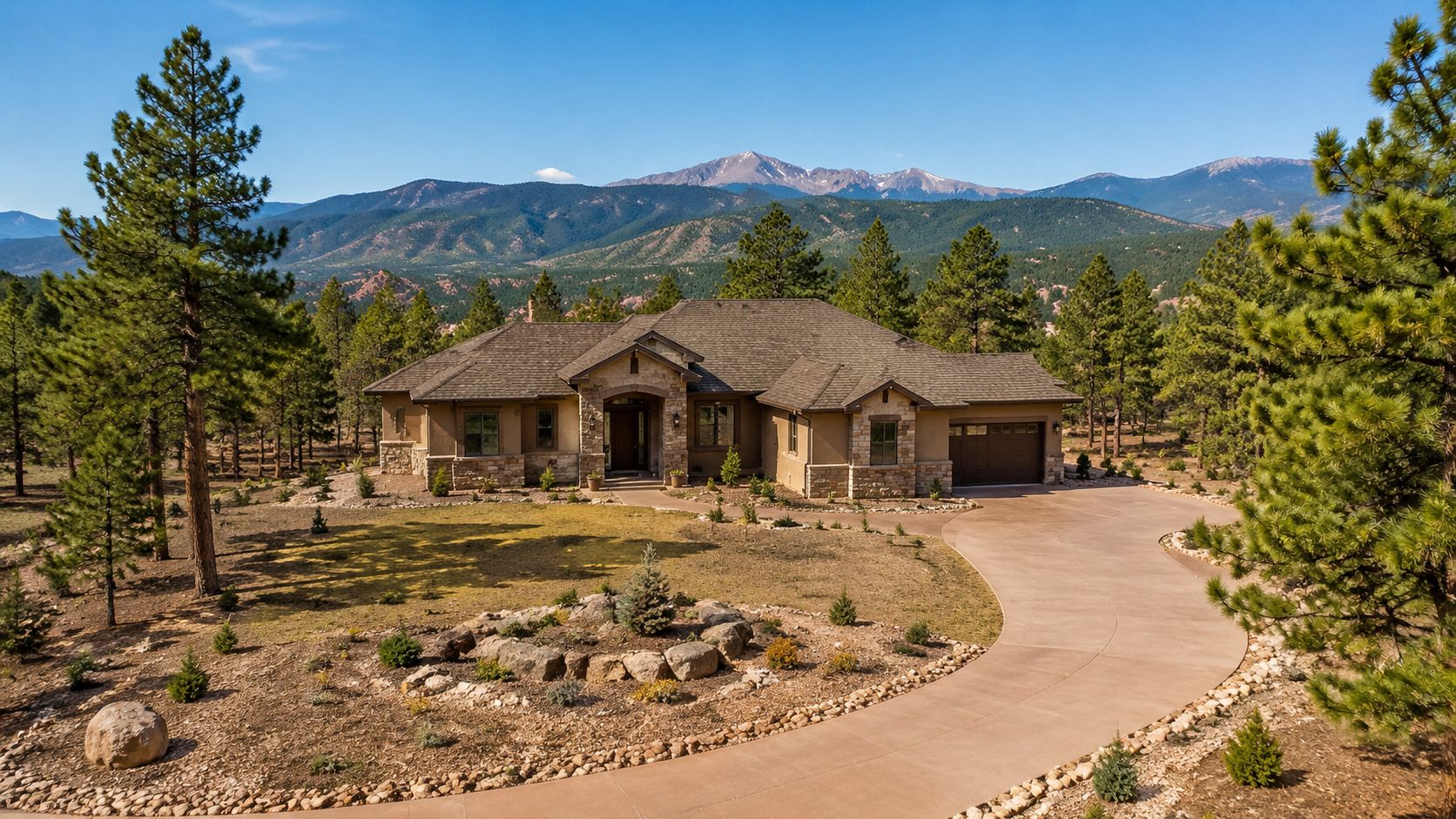 A luxurious house with a stone facade located in a mountainous region with pine trees and driveway.